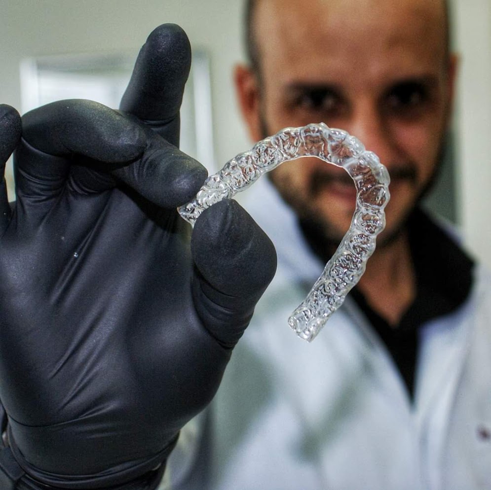 Dr. Daniel Prudente segurando um alinhador transparente